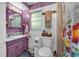 Cozy purple bathroom featuring tile flooring and a large vanity, toilet, and shower with patterned curtain at 1000 E Anderson St, Orlando, FL 32801