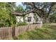 Charming exterior view of a two story Tudor-style house surrounded by lush landscaping and a quaint wooden fence at 1000 E Anderson St, Orlando, FL 32801
