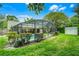 Beautiful backyard featuring a screened in pool, lawn, mature landscaping, and a storage shed at 10119 Bayard Ct, Orlando, FL 32836