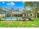 Spacious backyard featuring a screened in pool, lush lawn, and mature landscaping at 10119 Bayard Ct, Orlando, FL 32836