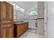 Well-lit bathroom featuring a double vanity, tiled shower, and ample cabinet storage at 10119 Bayard Ct, Orlando, FL 32836