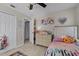 Bright bedroom featuring neutral walls, ceiling fan, and a large closet with a princess themed bed and decor at 10119 Bayard Ct, Orlando, FL 32836