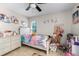 Cozy bedroom with ceiling fan, princess themed decor, and a window letting in natural light at 10119 Bayard Ct, Orlando, FL 32836