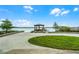 Waterfront property with a gazebo and a boat dock on a sunny day with lush green grass and a large concrete area at 10119 Bayard Ct, Orlando, FL 32836