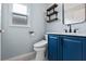 Bathroom with blue vanity, marble countertop, black faucet, and decorative shelves at 1018 Oceanbreeze Ct, Orlando, FL 32828