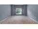 Empty bedroom showcasing neutral carpet and light blue walls, complemented by a window for bright natural light at 1018 Oceanbreeze Ct, Orlando, FL 32828