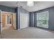 Carpeted bedroom with blue walls, window, closet, and chandelier at 1018 Oceanbreeze Ct, Orlando, FL 32828