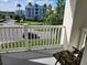 Enjoy the view from this balcony, overlooking a street and nearby buildings, with a comfortable chair for relaxing outdoors at 1021 Siena Park E Blvd # 301, Celebration, FL 34747