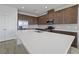 Spacious kitchen showcasing a large island with quartz countertops, stainless steel appliances, and tile flooring at 1026 Vineyard Ridge Rd, Minneola, FL 34715