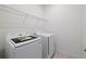 Modern laundry room with stainless steel appliances and wire shelving at 1026 Vineyard Ridge Rd, Minneola, FL 34715