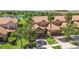 Aerial view of the property featuring tile roofs, landscaping, garages, a lake, and palm trees; neighborhood scenery at 10743 Belfry Cir, Orlando, FL 32832