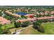 Idyllic aerial view of townhomes nestled beside a serene lake and lush green golf course at 10743 Belfry Cir, Orlando, FL 32832