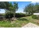 The backyard features green grass, mature trees, and nice landscaping at 10743 Belfry Cir, Orlando, FL 32832