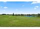 Scenic view of a well-maintained golf course with lush green grass, a pond, and residential buildings in the background at 10743 Belfry Cir, Orlando, FL 32832