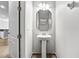 This half-bath has a decorative mirror and a classic pedestal sink on tile flooring at 10743 Belfry Cir, Orlando, FL 32832