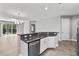 Bright kitchen with stainless steel dishwasher and sink, opening to living area with natural light at 10743 Belfry Cir, Orlando, FL 32832