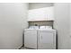 The laundry room has a washer and dryer and storage cabinets above at 10743 Belfry Cir, Orlando, FL 32832