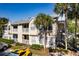 Tan two-story condo building with balconies and exterior stairwell, set amongst palm trees on a sunny day at 1089 S Hiawassee Rd # 314, Orlando, FL 32835
