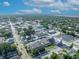 Bird's eye view of a town featuring commercial buildings, quaint houses, and lush green trees against a blue sky at 1110 Virginia Ave, St Cloud, FL 34769