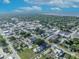 An aerial view captures a mix of residential homes and commercial properties near a lake, framed by green trees at 1110 Virginia Ave, St Cloud, FL 34769