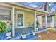 Inviting front porch with a blue deck, adorned with potted plants and comfortable seating, enhancing curb appeal at 1110 Virginia Ave, St Cloud, FL 34769