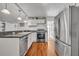 Bright kitchen featuring white cabinets, stainless steel appliances, and wood-look floors at 1110 Virginia Ave, St Cloud, FL 34769
