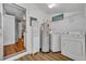 Laundry room includes washer, dryer, water heater, and shelving unit at 1110 Virginia Ave, St Cloud, FL 34769