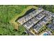 An aerial view features modern townhomes bordering a tranquil pond and lush greenery at 1123 Mahonia Ct, Lake Mary, FL 32746