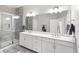 Modern bathroom features double vanity, large mirrors, shower with glass doors and contemporary fixtures at 1123 Mahonia Ct, Lake Mary, FL 32746