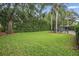 Large, grassy backyard featuring mature trees, manicured hedges, and a fenced pool area at 11345 Preserve View Dr, Windermere, FL 34786