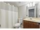 Neutral bathroom featuring a tub and shower with a shower curtain, tile flooring and a wood vanity at 11345 Preserve View Dr, Windermere, FL 34786