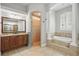 Bathroom showcasing a soaking tub, a window with shutters, and glass shower with tile details at 11345 Preserve View Dr, Windermere, FL 34786