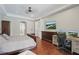 Primary bedroom featuring a hardwood floor, tray ceiling, a large dresser and a desk at 11345 Preserve View Dr, Windermere, FL 34786