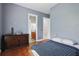 Bedroom with hardwood floors, stylish decor, blue accent wall, and doorway to en-suite bathroom at 11345 Preserve View Dr, Windermere, FL 34786