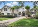 Stately two-story stucco home with a paver driveway, lush landscaping, and a basketball hoop above the garage at 11345 Preserve View Dr, Windermere, FL 34786