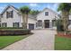 Charming home featuring a well-maintained lawn, manicured landscaping, stone accents, and a large driveway at 11345 Preserve View Dr, Windermere, FL 34786