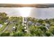 Picturesque aerial view of lakefront homes, lush landscapes, and a serene lake with a warm sunset backdrop at 12228 Kirby Smith Rd, Orlando, FL 32832