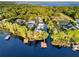 Aerial view showing lakefront homes and a boat dock surrounded by a lush green forest and calm water at 12228 Kirby Smith Rd, Orlando, FL 32832