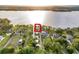 Aerial view of property outlined in red, showcasing a lakefront house and dock surrounded by lush greenery at 12228 Kirby Smith Rd, Orlando, FL 32832