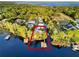 Aerial view of a lakefront property featuring a house with a dock, outlined in red, and lush green trees at 12228 Kirby Smith Rd, Orlando, FL 32832