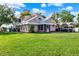 Two-story house with lush green lawn featuring a screened porch, two vehicles, and an upper level balcony at 12228 Kirby Smith Rd, Orlando, FL 32832