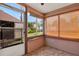 A sunroom features large windows with views of the surrounding greenery and offering a bright, relaxing space at 12228 Kirby Smith Rd, Orlando, FL 32832