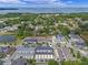 Scenic aerial view of a community with blue townhomes located close to a lake and lush greenery at 1324 Painted Bunting Ave, Oakland, FL 34787