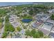 Expansive aerial view of a neighborhood featuring a pond, community pool, and sidewalks at 1324 Painted Bunting Ave, Oakland, FL 34787