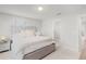 Serene bedroom with a tufted headboard bed, neutral decor, and a glimpse into the en suite bathroom at 1324 Painted Bunting Ave, Oakland, FL 34787