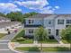 Beautiful two-story townhome with blue accents, a manicured lawn, and an inviting front porch seating area at 1324 Painted Bunting Ave, Oakland, FL 34787