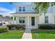 Charming two-story townhome featuring a covered front porch, well-manicured lawn, and welcoming entrance at 1324 Painted Bunting Ave, Oakland, FL 34787