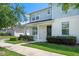 Two-story townhome boasts a covered front porch, verdant lawn, and inviting facade at 1324 Painted Bunting Ave, Oakland, FL 34787