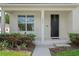 Inviting front porch with white rocking chairs, decorative door wreath, and landscaped garden at 1324 Painted Bunting Ave, Oakland, FL 34787