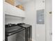 Modern laundry room with side-by-side washer and dryer and storage cabinets at 1324 Painted Bunting Ave, Oakland, FL 34787